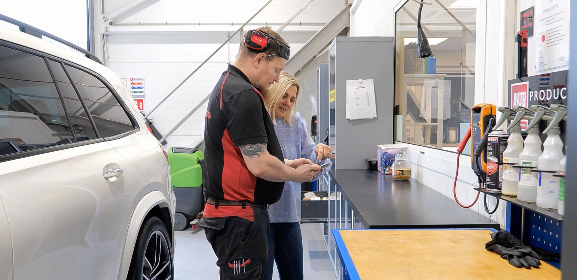 Leder veileder ansatt i nytt HR-system på mobiltelefon.